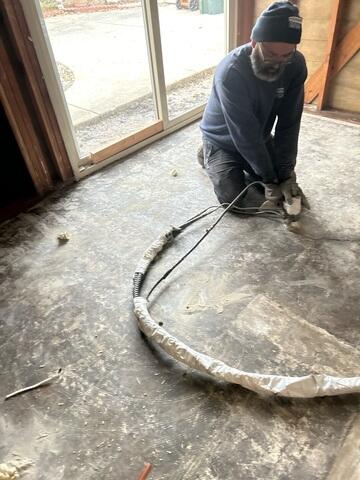 Progress image of the PolyLevel foam being injected to fill any voids left under the slab after the home had been lifted.