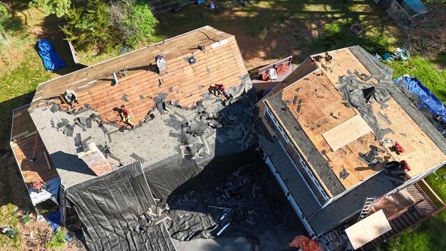 In this photo, the crew has stripped away the old shingles and underlayment, leaving the decking exposed. This crucial step allows us to thoroughly inspect the structure and ensure the roof is in good condition before applying the new layers. Any damaged decking will be replaced, providing a strong, solid foundation for the new roof system.