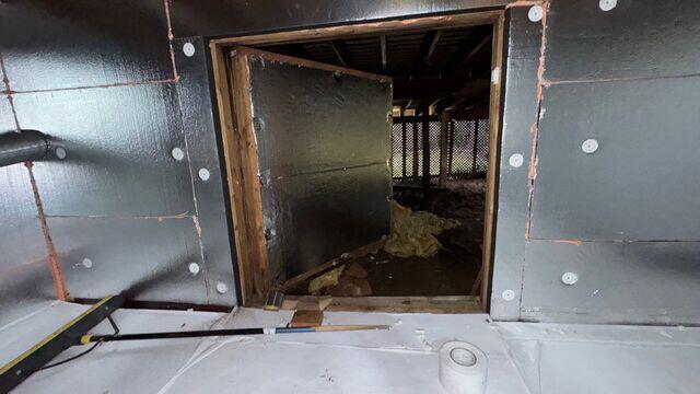 The door from the crawl space to the space underneath the three-season room, during the crawl space encapsulation.