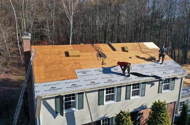 This photo shows the beginning stages of waterproofing the roof after the tear-off is complete. Once we've confirmed that the plywood decking is in solid condition and replaced any damaged or rotted boards, we move on to applying the first protective layers. Here, you can see our crew starting to install the SealoronXT Ice & Water shield along the roof's most vulnerable areas, such as the eaves and valleys. This step is critical for preventing leaks caused by ice dams or heavy rain. Next, we apply SealoronXT Deck Tape over all the seams in the plywood to seal any gaps and help the roof breathe while staying watertight. Finally, we cover the remaining surface with VeloraOne Roof Underlayment, which acts as a final barrier against water until the shingles go on. These layers work together to ensure long-term protection and durability for the entire roofing system.