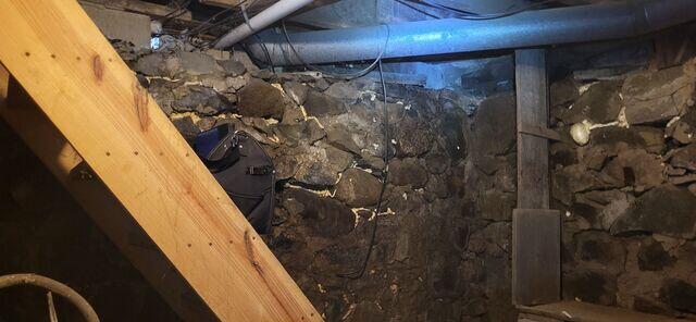 Stone Foundation: This picture was taken by our inspector upon initial inspection. These stone walls were caving in, and needed a special repair system to stabilize them.