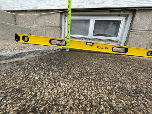 A close-up of the bump that had started forming where the step and sidewalk meet.