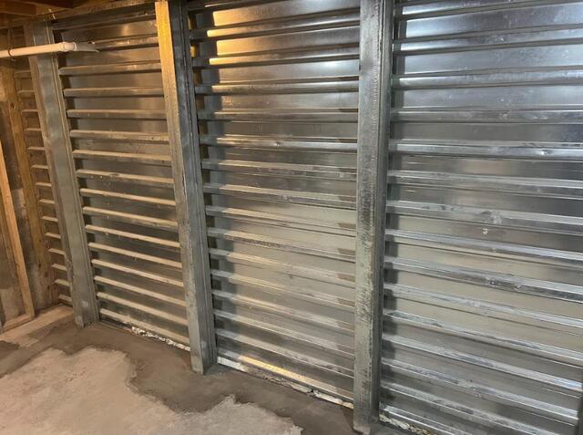 Another photo of the completed installation. The reinforced panels cover the entire failing wall, along with the I-beams that are attached at the floor and joists. If you look close enough at the bottom, you can see very small gaps where our WaterGuard system is actually installed along the wall. Water is collected here and sent to our sump pump.