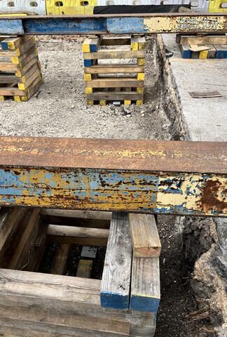 Cribbing and beam tracks placed above helical piers