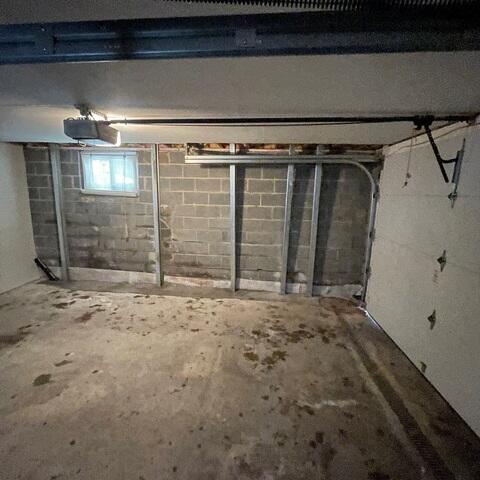 The bowing garage wall in this photo, is now fully secured with the PowerBrace System which is secured into the beams above and concreted in to the ground below and can be adjusted as time goes on, so that the wall is held securely.