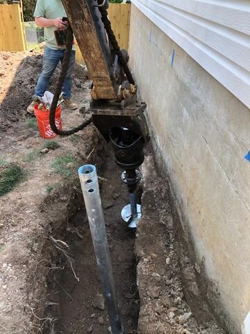 In this photo, our crew is installing Helical Piers after completing the excavation around the foundation in Chantilly, VA. These deep foundation supports are drilled into stable soil to permanently stabilize and lift the structure. Helical Piers are a trusted solution for homes experiencing settlement and sinking foundations.