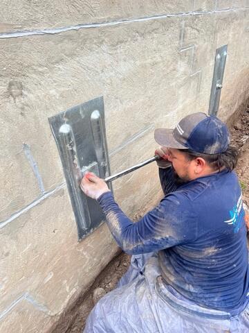 This photo shows one of our skilled technicians tightening the GeoLock® Wall Anchors during a foundation repair in Chantilly, VA. This step is crucial for securing the anchors and applying steady pressure to stabilize and straighten the foundation wall over time. It's part of the proven process we use to permanently correct bowing or shifting walls.