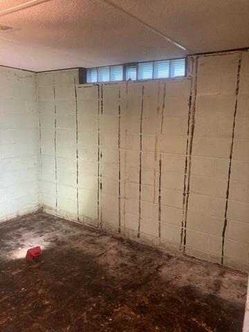 This photo shows the wall after the paneling was taken down, revealing the extent of the water damage underneath. The deterioration along the base clearly indicates that moisture has been an ongoing issue for quite some time.