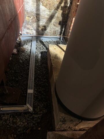 The crew also added TrenchDrain to provide an extra layer of surface water control. It efficiently captures and diverts runoff before it can seep into the foundation, enhancing the overall drainage system and keeping the space dry and protected from flooding.