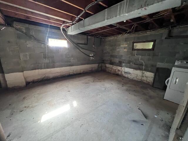 Vertical cracks and dampness in this unfinished cinderblock basement before repairs.