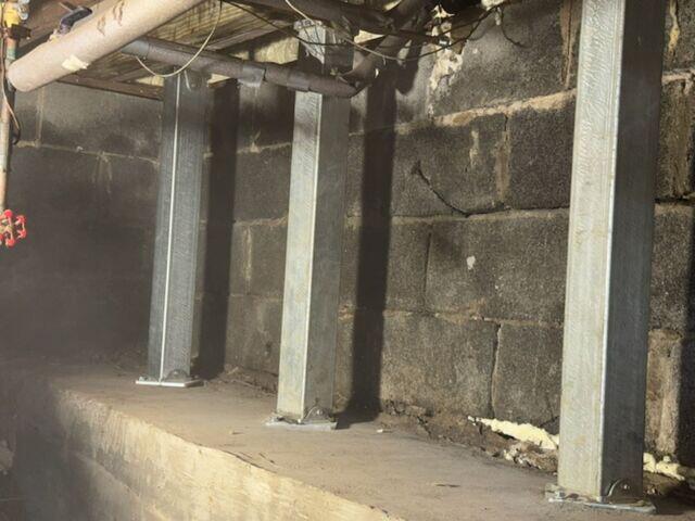 The SmartJack Support System was added to stabilize and lift sagging floor joists, restoring structural integrity and preventing further settlement beneath the home.