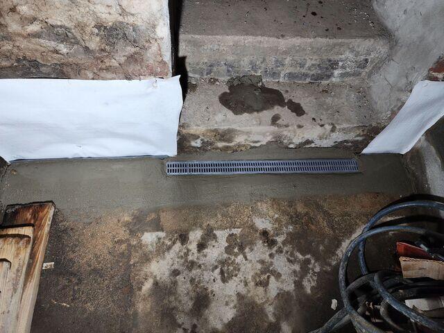The TrenchDrain System was installed at the basement entryway to prevent surface water from entering, while CleanSpace Wall Panels create a moisture-resistant barrier that improves air circulation and keeps walls dry for a healthier basement environment.