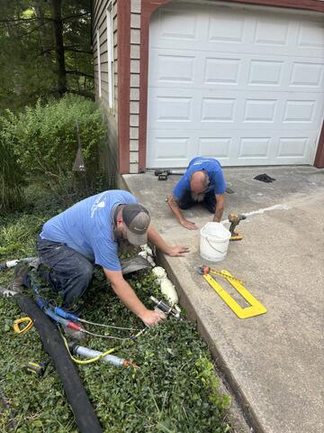 This photo shows both of our Techs putting the final touches on the project. David, to the left, is sealing any voids underneath the slab on the hillside. Keith, to the right, is matching the color of the sealant to the existing concrete.