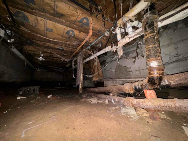 This dirt-floor crawl space in Brooklyn was damp, musty, and puddled with water after rainstorms.