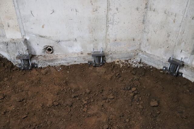 The soil is then put back to cover the holes and a vapor barrier covers the soil. This homes foundation is now secured.