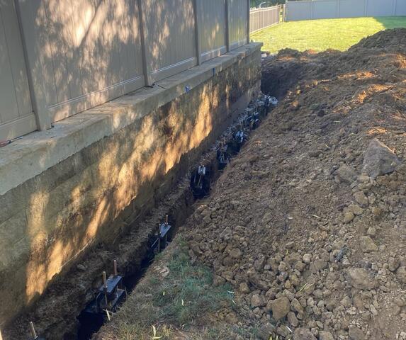 This photo shows a set of our helical piers attached to the patios footing. Continue to scroll through the attached photos to learn more!