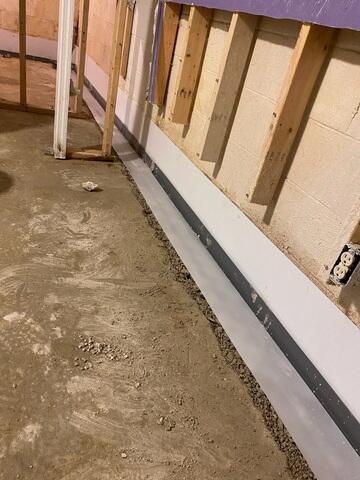 This photo shows the waterproof tape we rolled over the drainage system. This tape may seem insignificant, but it will help stop moisture from transferring into the concrete. It will also help us create a nice float of concrete over the system.