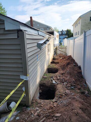 To begin the repair, our crew carefully excavated the soil around the garage's foundation and installed heavy-duty steel Push Piers beneath the footing, driving them deep into stable, load-bearing strata to ensure lasting support.