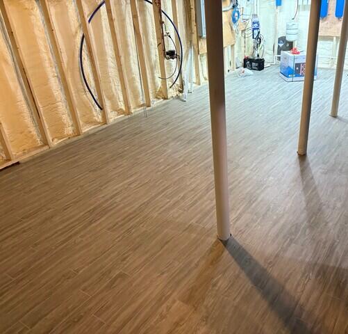 The Elite Plank Flooring in Gray elevates the look of this basement while also being waterproof and working seamlessly with our other products.