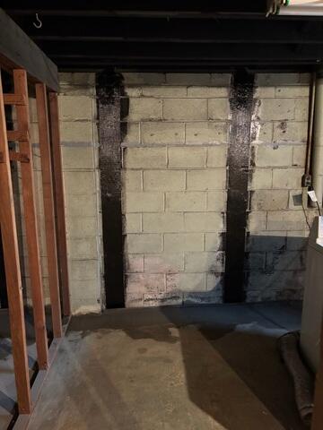 CarbonArmor straps fully installed along the wall, providing permanent reinforcement and preventing further bowing.
