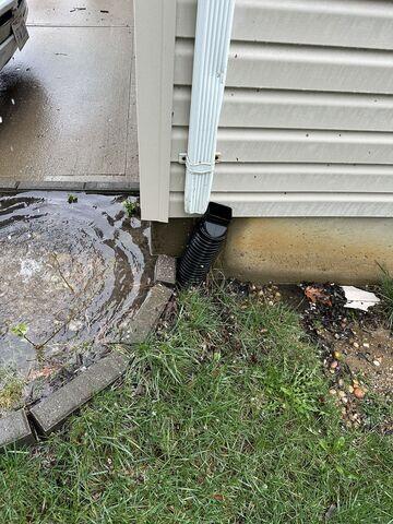 This photo shows the disconnection between the downspout and the discharge line. All the water leaked out of the downspout and puddled off to the left of the photo. This photo was also taken upon the initial inspection. We would later reconnect the downspout to the line that runs under the ground.