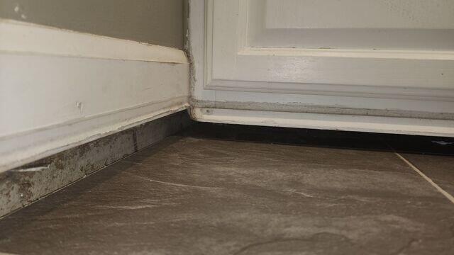 This picture shows the gap between the baseboard and the tiled floor in the kitchen above the crawl space.