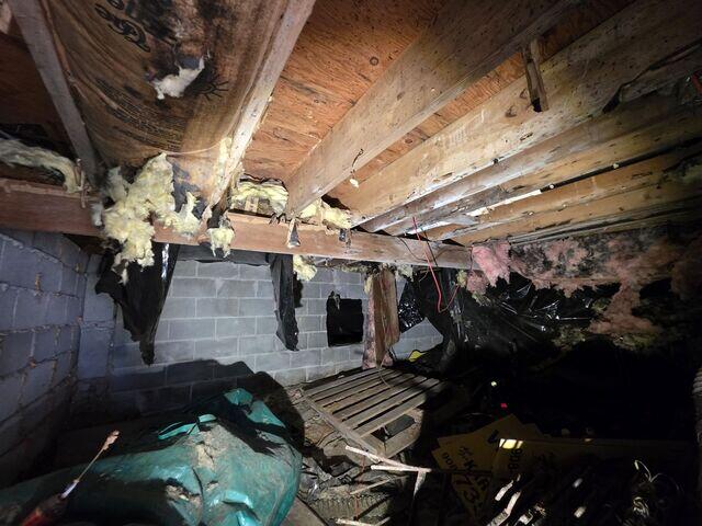 The crawl space showed exposed dirt and damaged insulation, allowing moisture and musty air to rise into the home.