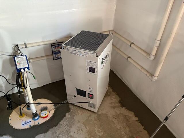 The SaniDry XP dehumidifier keep humidity in the basement low and drains itself into the TripleSafe sump pump. The TripleSafe sends all of the water out of the home through the discharge lines.