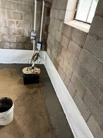 This was what the system looked like upon completion. We covered the drains with a fresh concrete layer. Although concealed, the WaterGuard has a tiny wall flange sticking up out of the floor and against the walls to be able to capture wall leaks. The TripleSafe sump pump was fitted with three different pumps inside the liner, including one pump that is backed by a battery backup system in case of power failure.