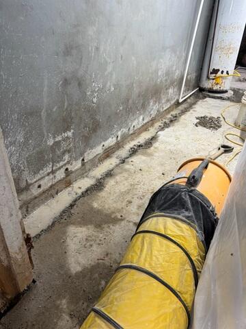 This photo shows the trenches opened up, the weeping holes drilled, and our negative air system sucking up dust.