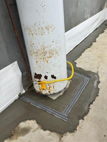 This was where we encased the base of the water heater with a trench drain system. If this water heater ever leaks, the water will be captured by the drainage system.