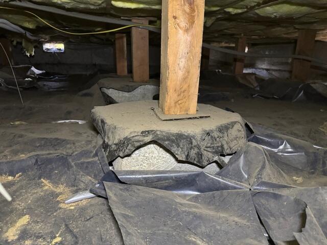 Without a proper barrier or protection on the footing of wooden posts, there is a higher chance of water absorbing since concrete is a porous material, it can cause wood rot to the posts that can lead to sagging floors. This damaged plastic was doing no good in this space.