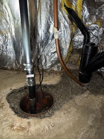 The damp crawl space resulted from a combination of heavy rainfall/ground moisture intrusion and an old, failing sump pump. The inadequate pump could not efficiently manage the water entering the space, leading to a critical lack of proper drainage support.