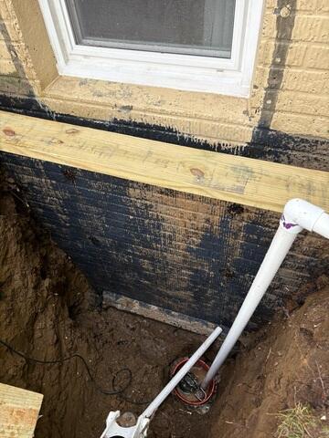 Drainage system being installed on exterior of the home.