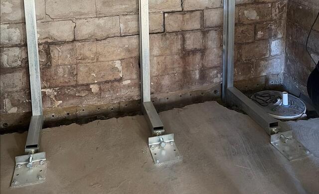 This photo, cropped from the previous, shows a closer up view of the shearing. If you look closely at the bottom most row of blocks, (the one with weep holes drilled in them) you'll notice that the whole entire wall was sliding over it. Shearing like this occurs because the bottom most row of blocks are held back by the floor slab, while the rest of the entire wall has nothing to hold it back. This was a sure sign of shearing at a very late stage.