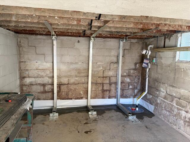 We also suggested that we waterproof the wall to help relieve pressure off of the wall and to keep the basement dry. We fitted the base of the now straight wall with our subfloor WaterGuard drains, and hooked them up to one of our sump pumps. The homeowner told us he didn't mind the floor braces, (which were needed) and they would just throw their work bench over them.