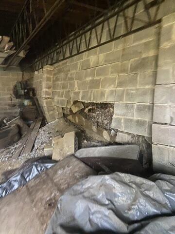 This photo, taken from a completely different site, shows what can happen if wall failure is left ignored. Unfortunately, this garage in New Richmond, OH, had to be completely demolished, as this total wall failure left the entire structure unsafe to even stand in.