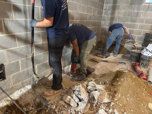 Our crew carefully excavating around the basement foundation to prepare holes for the Push Piers.