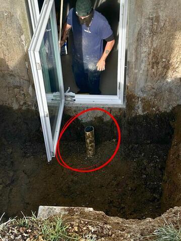 This close up shows the drain tie-in we hooked up to the existing footer drains. We then filled the base of the well up with gravel to make the gravel floor flush with the top of the drain. The drain was capped with a grate to prevent debris from entering.