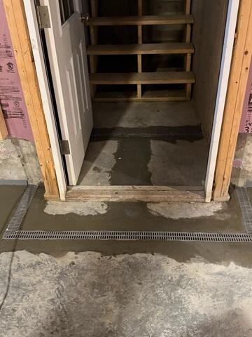 WaterGuard® Interior Drainage System:
Installed along the basement perimeter to collect groundwater seepage from the wall-floor joint and direct it efficiently to the sump system.
TrenchDrain™ System:
Installed at the base of the bulkhead stairs and other key entry points to intercept and channel surface water directly into the WaterGuard® system.
IceGuard® Discharge Line Protection: