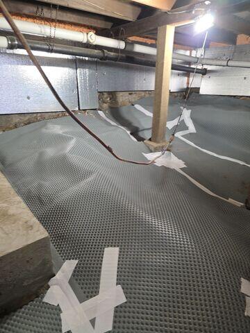 Drainage Matting was placed across the crawl space floor to create a raised pathway that directs groundwater toward the drainage system.