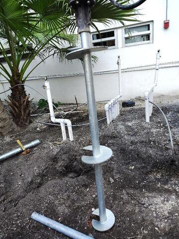 Installing helical piles around Coy Pond utilities.