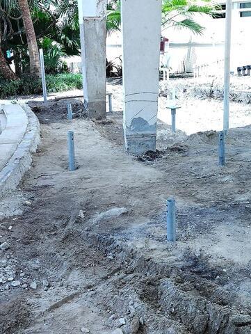 Helical piles are installed with new construction brackets positioned.