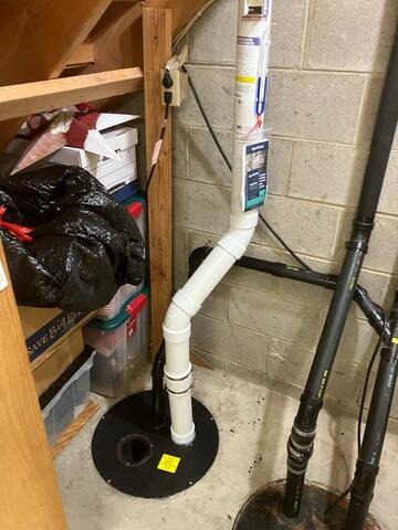 The PVC pipe was installed through the sump pump and is connected to the fan outside