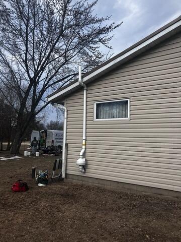 The fan is installed at the exterior of the home to expel the radon gas