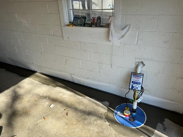 Finished Project: We installed our SmartSump right near the garage door so we could run the discharge line right onto the sloped driveway, (just outside this wall). The discharged water will safely run down the driveway away from the home.