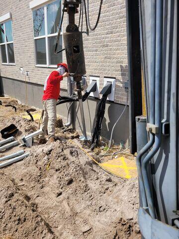 Installing helical pier around utilities.