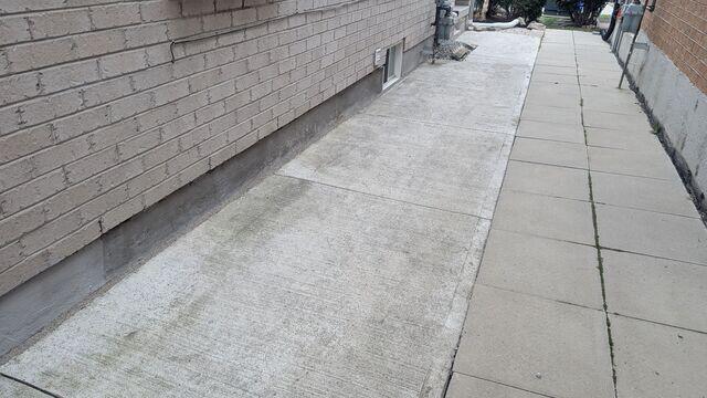 Leveling the walkway corrected the slope to shed water away from the walls. Trip hazards were eliminated, and the drainage path is now functional again.