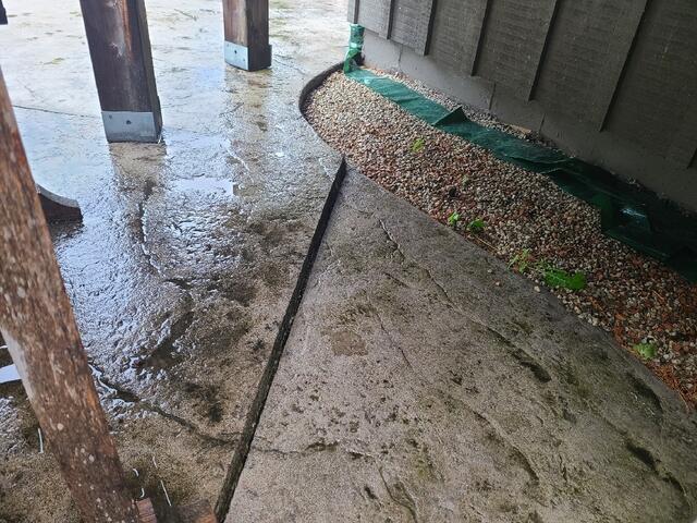 This angle shows the severity of the tilt near the backyard. As the slabs sank, they began to slope toward the home's foundation and structural rock tiers. Without leveling, rain and snowmelt would be directed straight toward the house, risking long-term structural damage and making the patio area virtually unusable for outdoor furniture.