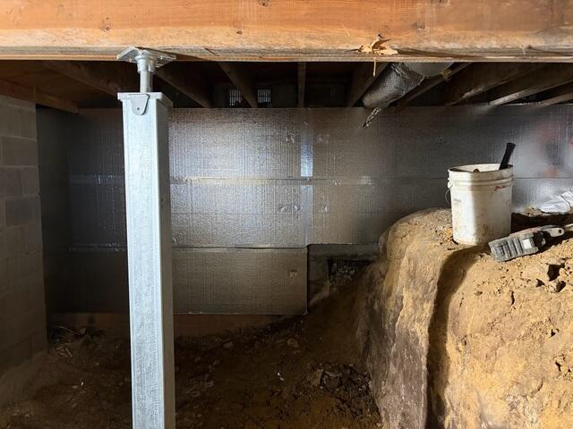 This photo shows our SilverGlo insulation panels across the wall. These panels reflect heat back into the room. You can also see the steel SmartJack we installed to replace the wooden post seen in the previous photo.